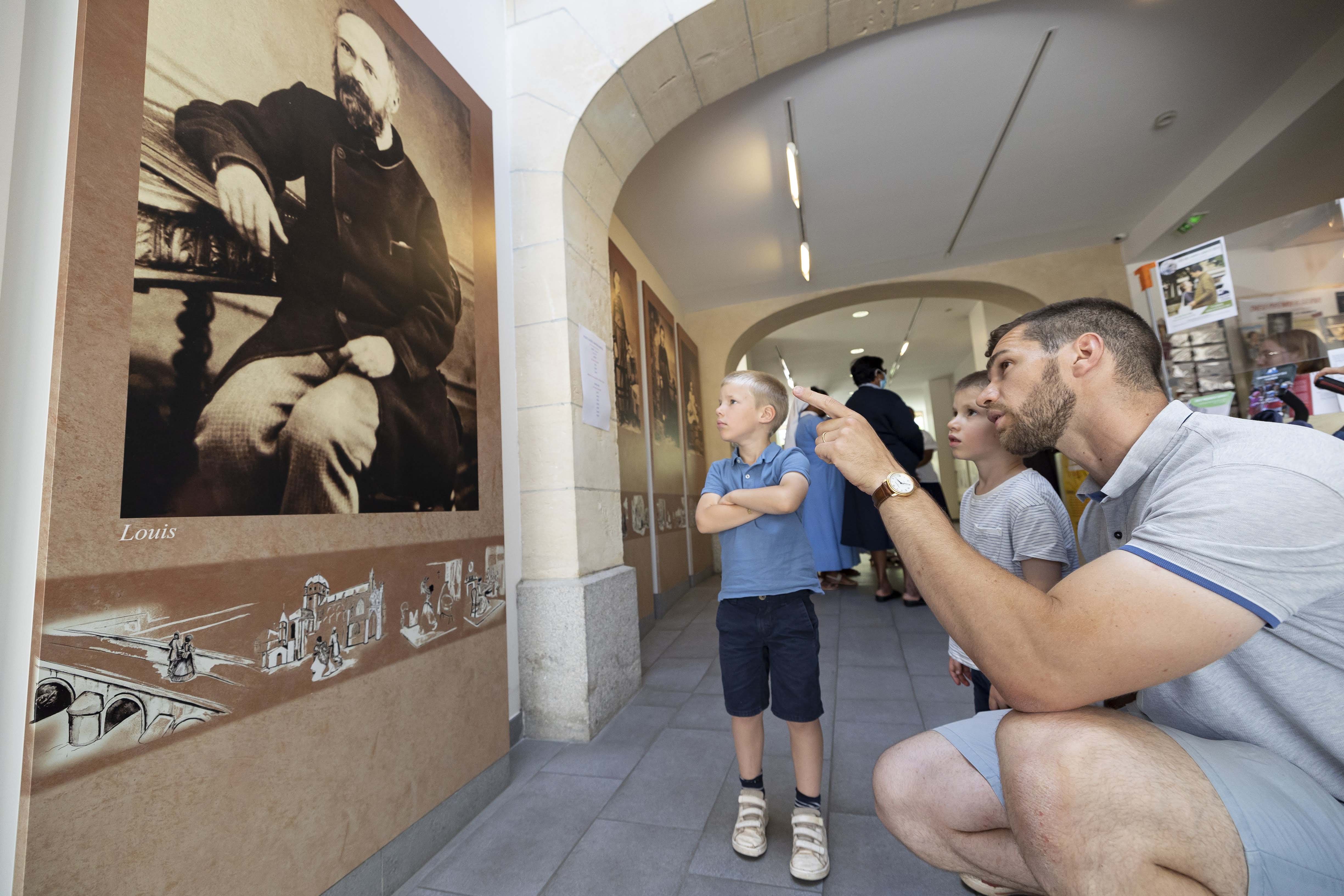 Un père et son fils regarde une oeuvre dans le sanctuaire d'Alençon